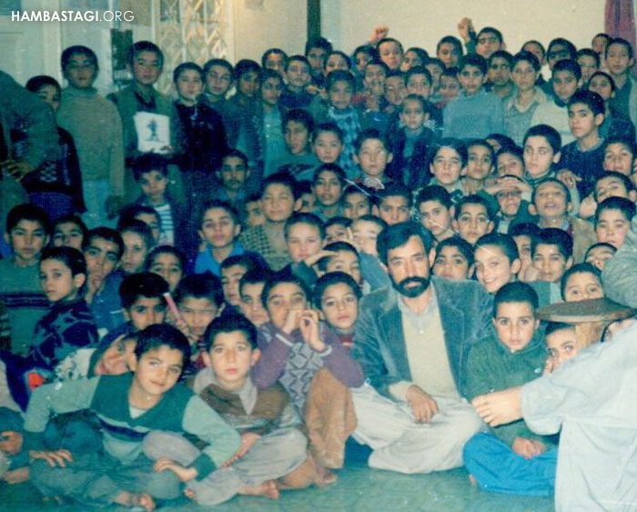 استاد علی‌رضا احمدی در کنار کودکان مهاجر یکی از مکاتب در پاکستان (سال ۱۳۶۶)