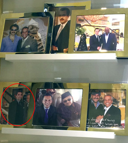 بیژن پاکزاد در گوشه‌ای از فروشگاه تصاویرش را با مشتریان همیشگی‌ به نمایش گذاشته است. (عکس از:‌ روزنامه «اطلاعات روز»)